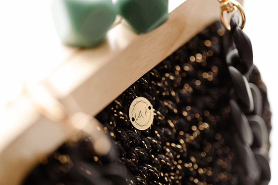 NUBAI - elegancka torebka, pleciona z czarnym łańcuchem - czarna z zielonym uchwytem